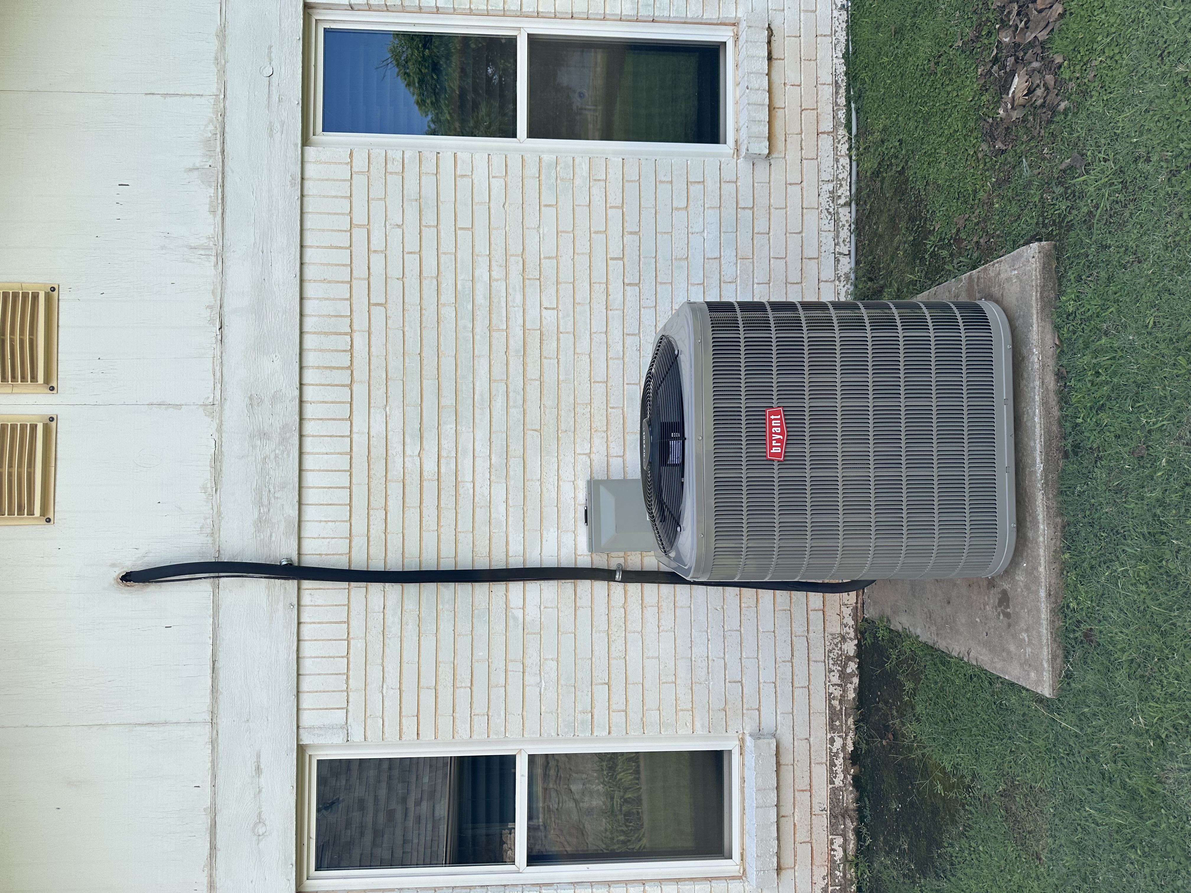 Two outdoor central air conditioning units installed on concrete pads next to a building, ready for operation.