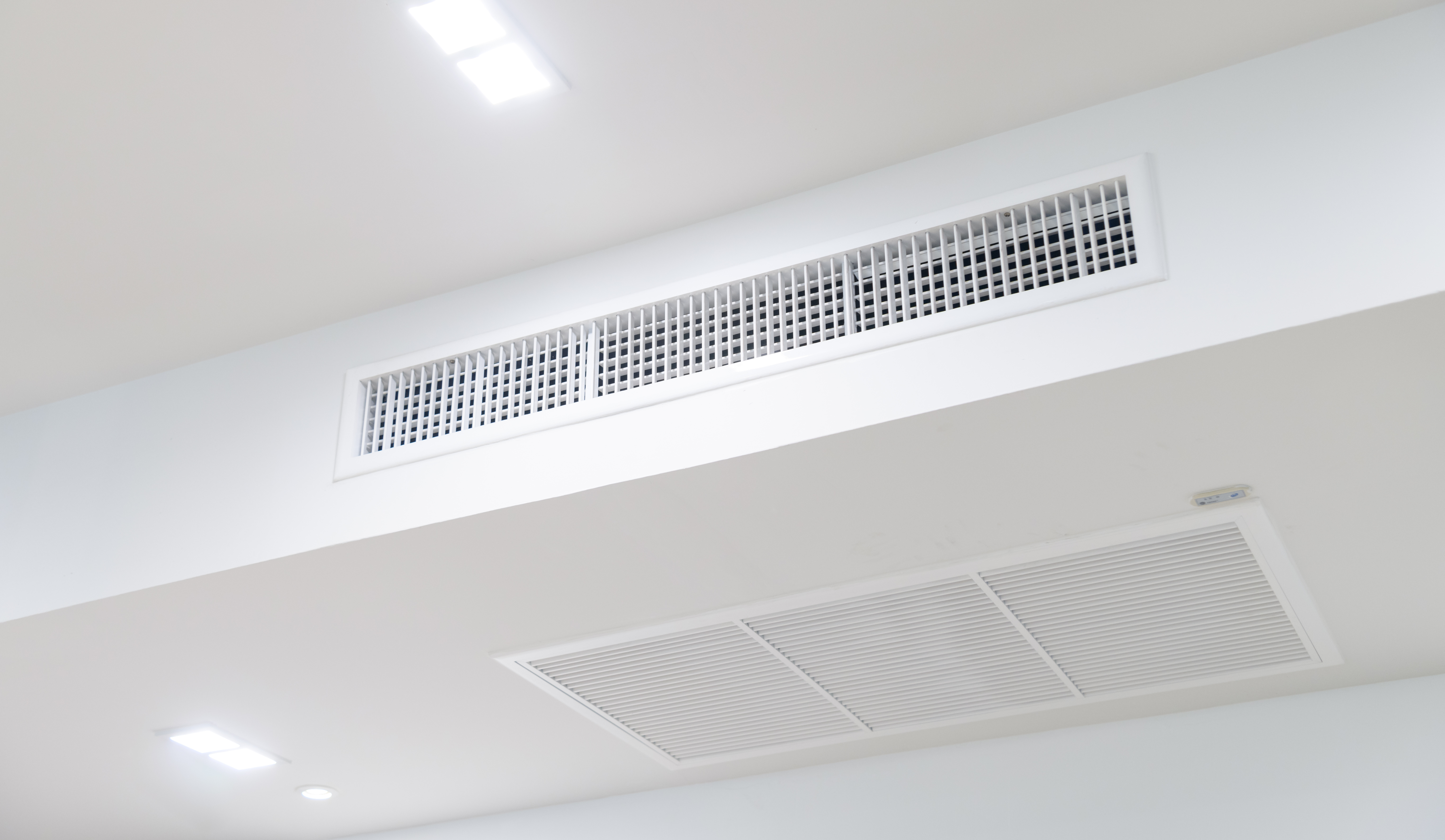 Wall-mounted air conditioning unit installed in a stylish interior with decorative ceiling molding, providing efficient cooling.